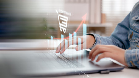 Hands typing on a laptop with an upward bar chart and e-commerce icon, symbolizing online sales growth, digital marketing, and business success in modern e-commerce platforms.の写真素材
