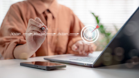 Businessman writing strategic process: Vision, Mission, and Action with a digital target icon, representing business goal setting, strategic planning, and performance execution workflow.の写真素材