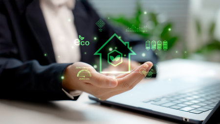 A businessman is holding a virtual eco-house icon with clean energy, zero-emission, renewable energy, and sustainable, eco-friendly living.の写真素材