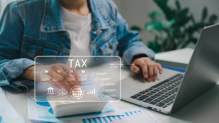 Digital tax form and online filing system with a businessperson using a calculator and laptop. Concept of e-tax, financial technology, accounting, and tax management app interface.の写真素材