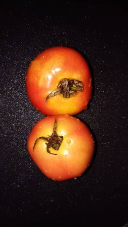 Ripe tomato on black backgroundの写真素材