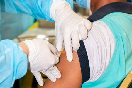 Close-up of a nurse preparing an injection to a patient.