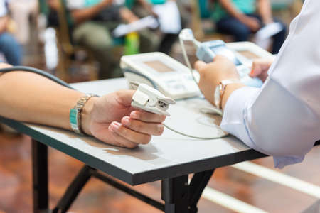 nurse taking blood pressure, blood sample before Covid 19 vaccine given to patientの写真素材