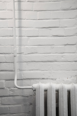 iron radiator against a white brick wallの写真素材