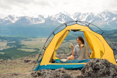 beautiful girl sits in a tent on mountainの写真素材