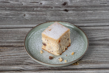 snack with delicious pie with sweet cottage cheese and raisins on a light green ceramic plate on a wooden backgroundの写真素材