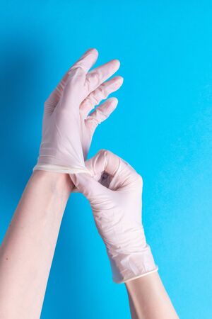 We put on surgical rubber gloves to protect against bacteria and viruses on a blueの写真素材