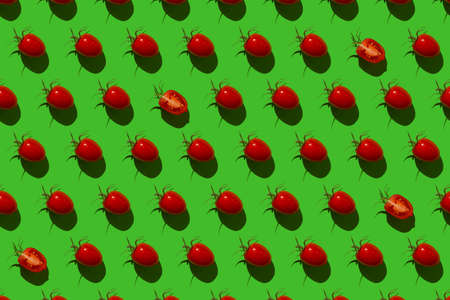 Pattern of Bulgarian sweet peppers, cherry tomatoes and cucumbers on a green backgroundの写真素材