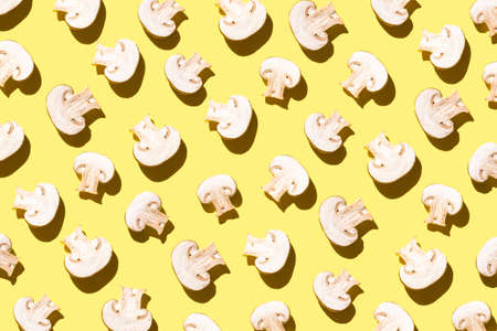 Pattern of cut champignons on a yellow light backgroundの写真素材