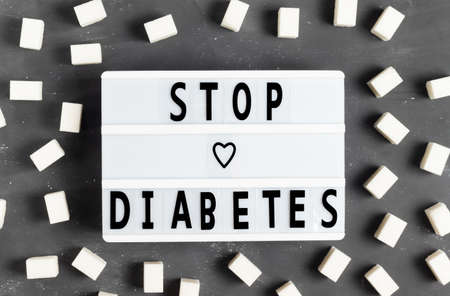 The inscription Stop diabetes on a white board on a gray background with sugar cubes for World Diabetes Day 4 Novemberの写真素材