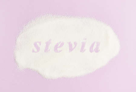 Inscription Stevia sugar substitute for diabetics on scattered stevia on a pink backgroundの写真素材