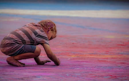 Manresa, Spain, August 24, 2012: Child painting the floor in a party of colors on one side of the picture.のeditorial素材