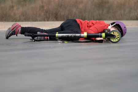 Little girls tumble: scooter accident on pavement.の写真素材