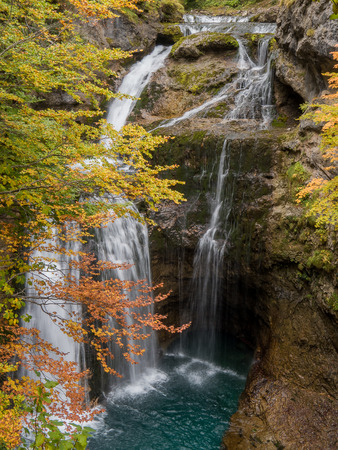 Waterfall in the forest in the mountains in autumnの写真素材