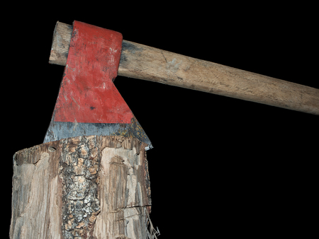 Old axe stuck in log isolated over black backgroundの写真素材