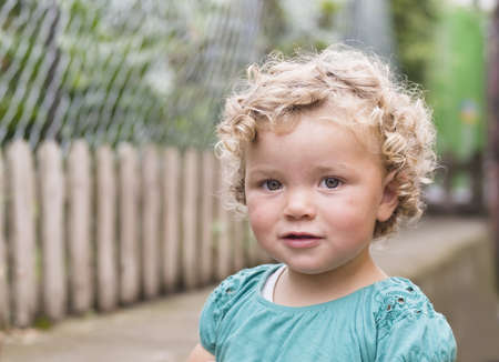 Little girl looking at camera smiling with a nice expressionの写真素材