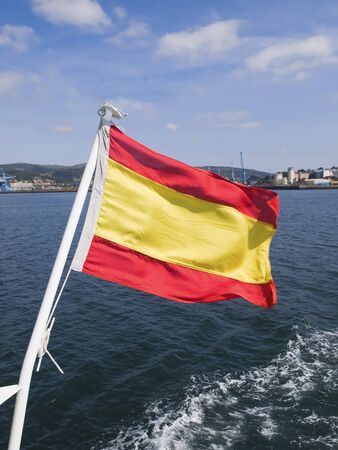 Spain flag waving in the sea in a sunny, breezy dayの写真素材
