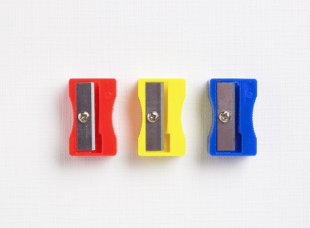 three different colors sharpener on white backgroundの写真素材
