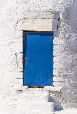 Blue door on white wall  This architectural detail is located in the greek island of Mykonos の写真素材