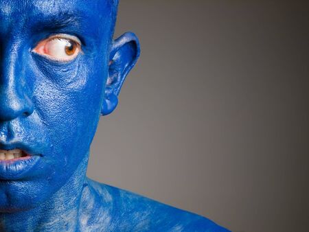 Face man blue with fear expression isolated on dark background.の写真素材