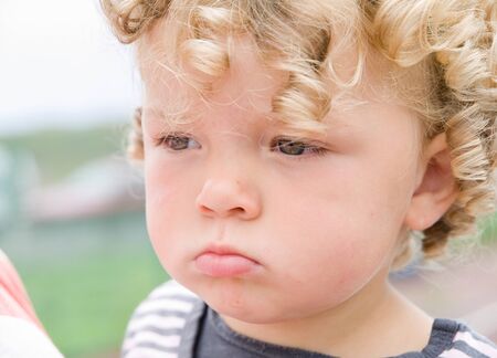 A blond hair girl with a seious expression on her faceの写真素材