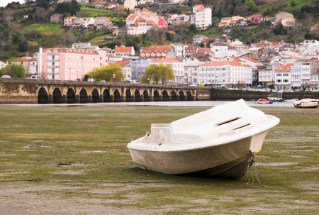 A boat at low tide in Pontedeume, Galicia, Spain の写真素材