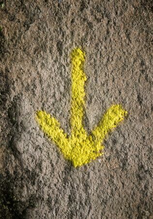 Arrow painted on a wall and pointing downの写真素材