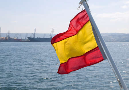 Spanish flag waving in a boat, on a sunny day の写真素材