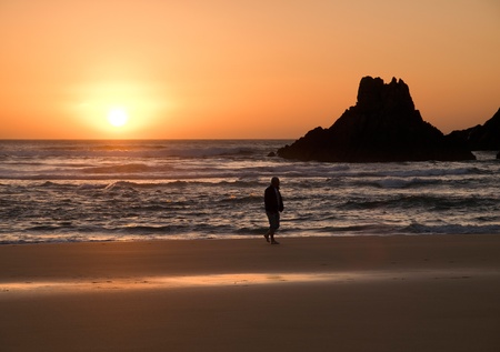 Sunsuet in the beach with a person walking の写真素材