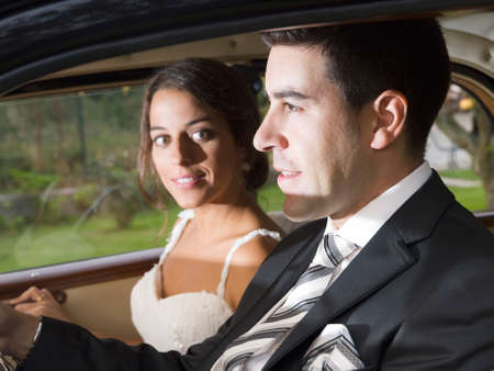 Married couple in a car. Man drives and woman is looking at himの写真素材