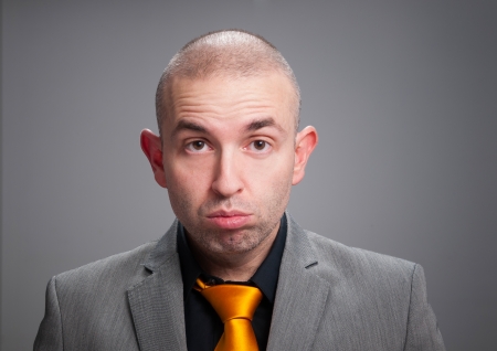 Businessman stressed in a studio portrait isolated on dark backgroundの写真素材