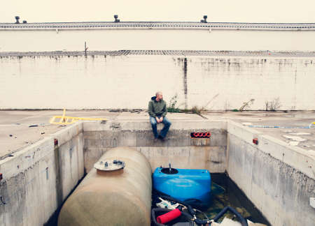 Man in the ruins of an industry outdoors in a cloudy day