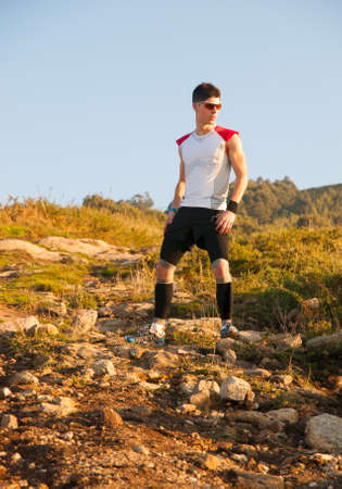 Man practicing trail running with a coastal landscape in the backgroundの写真素材