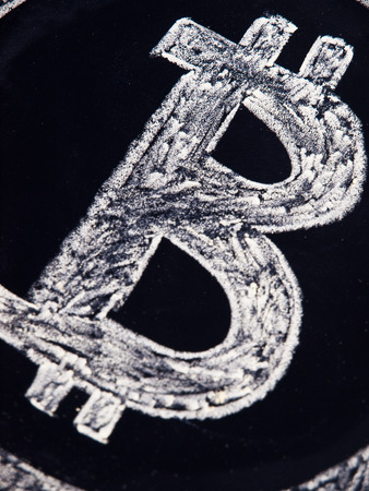 Bitcoin symbol isolated in a black board backgroundの写真素材