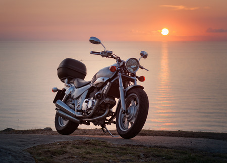 Custom Motorbike in a sunset with sea in the backgroundの写真素材