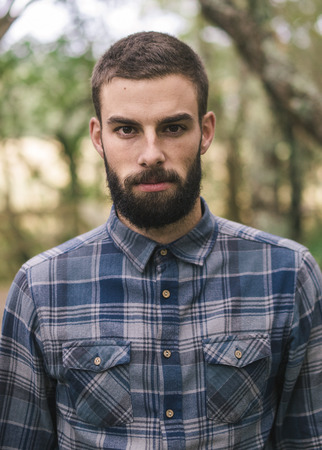 Hipster man portrait outdoors. Man is looking at camera.の写真素材