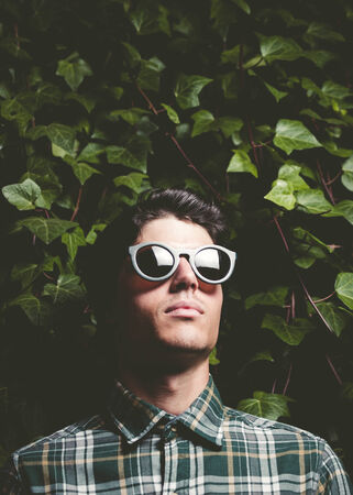 Portrait of a man wearing sunglasses outdoors and flash lightの写真素材