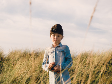 Little girl standing and looking at camera in nature outdoors