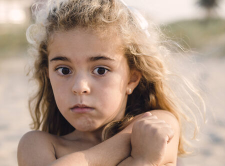 Portrait of a shy girl on the beachの写真素材