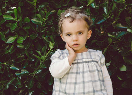 Little girl portrait in nature with leaves in the backgroundの写真素材