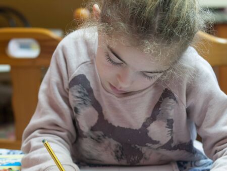 Little girl drawing at home. Girl is focus in her activity.