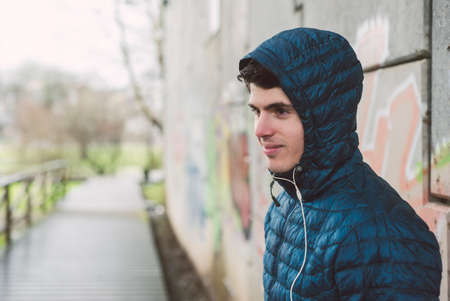 Runner man with headphones in an urban scene in winter outdoors in a rainy dayの写真素材