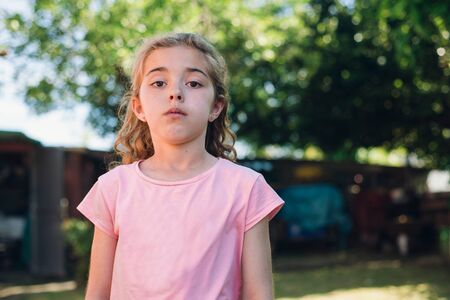 Little girl portrait with serious expression outdoors