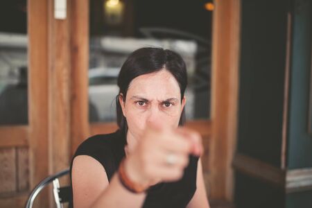Woman pointing with angry expression outdoorsの写真素材