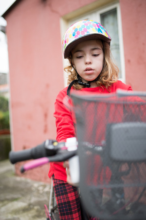 Little girl with her bicycle outdoors.の写真素材