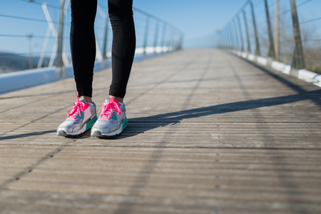 Detail of the legs of a woman stand up in a bridge outdoorsの写真素材