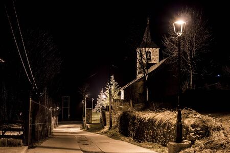 The village church illuminated at nightの写真素材