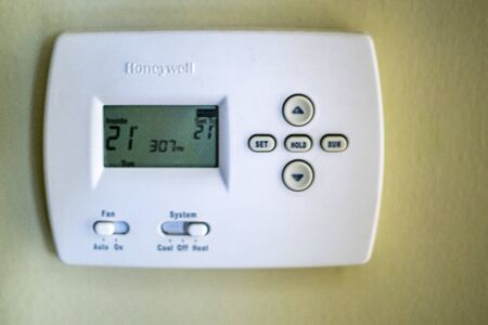A honeywell thermostat for home central heating fixed to a wall