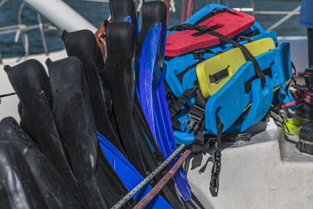 Safety swimming flippers and rubber floating belts on a catamaran for people who want to go for a...