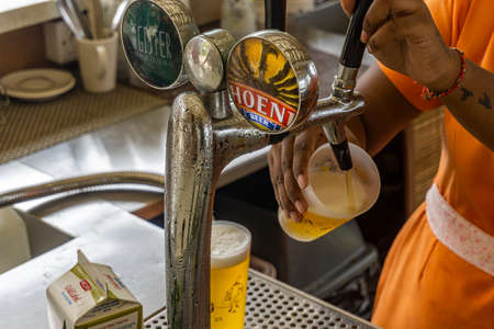 Barman filling glasses from a beer dispenserのeditorial素材
